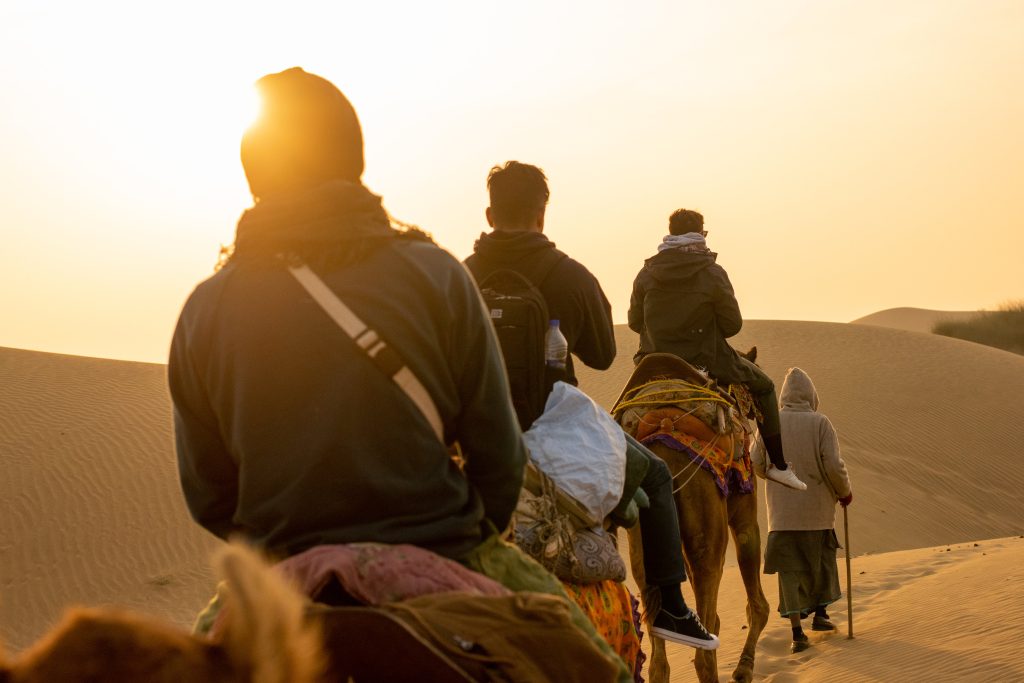 Camel trek through dunes at sunset in Rajasthan