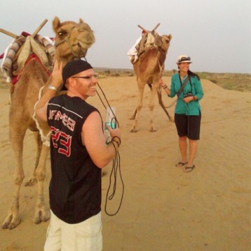 Travellers walking with camels in the desert